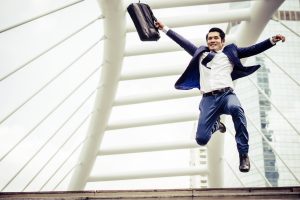 Man holding briefcase jumping in the air