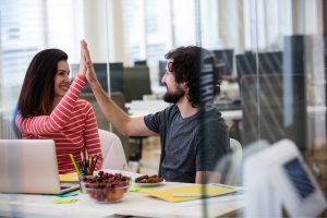 Woman and man high-fiving after achieving success