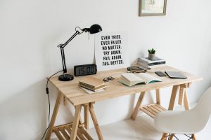 Study desk with books, clock, stationery, and a sign with inspiring words to give motivation