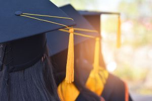 People graduating wearing diploma hats