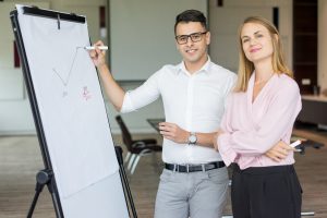 Man and woman standing in front of a flipchart learning ISO 9001:2015