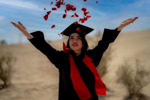 woman-wearing-black-graduation-gown-and-cap-celebrating